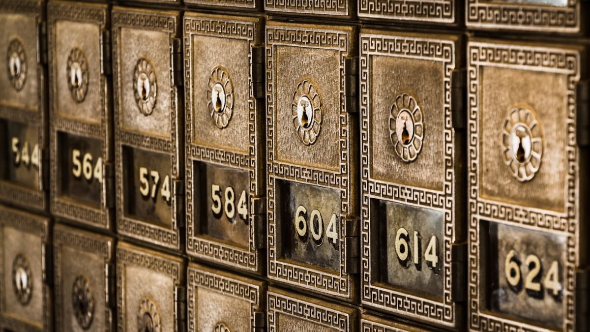 Fileiras de caixas de segurança metálicas numeradas, com fechaduras individuais.